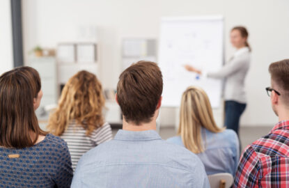 frau hält einen vortrag am flipchart vor einer gruppe frau hält einen vortrag am flipchart vor einer gruppe
